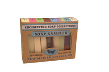 A packaged set of eight different types of soap bars labeled as the 'New Mexico Soap Collection'. The packaging is cardboard with a clear window showing each bar, and each bar is colored distinctly to represent different scents.